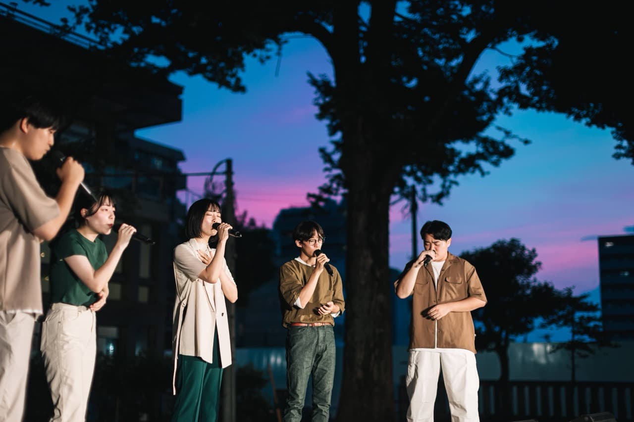 夕暮れの空のもと、ハーモニーを響かせる5人組